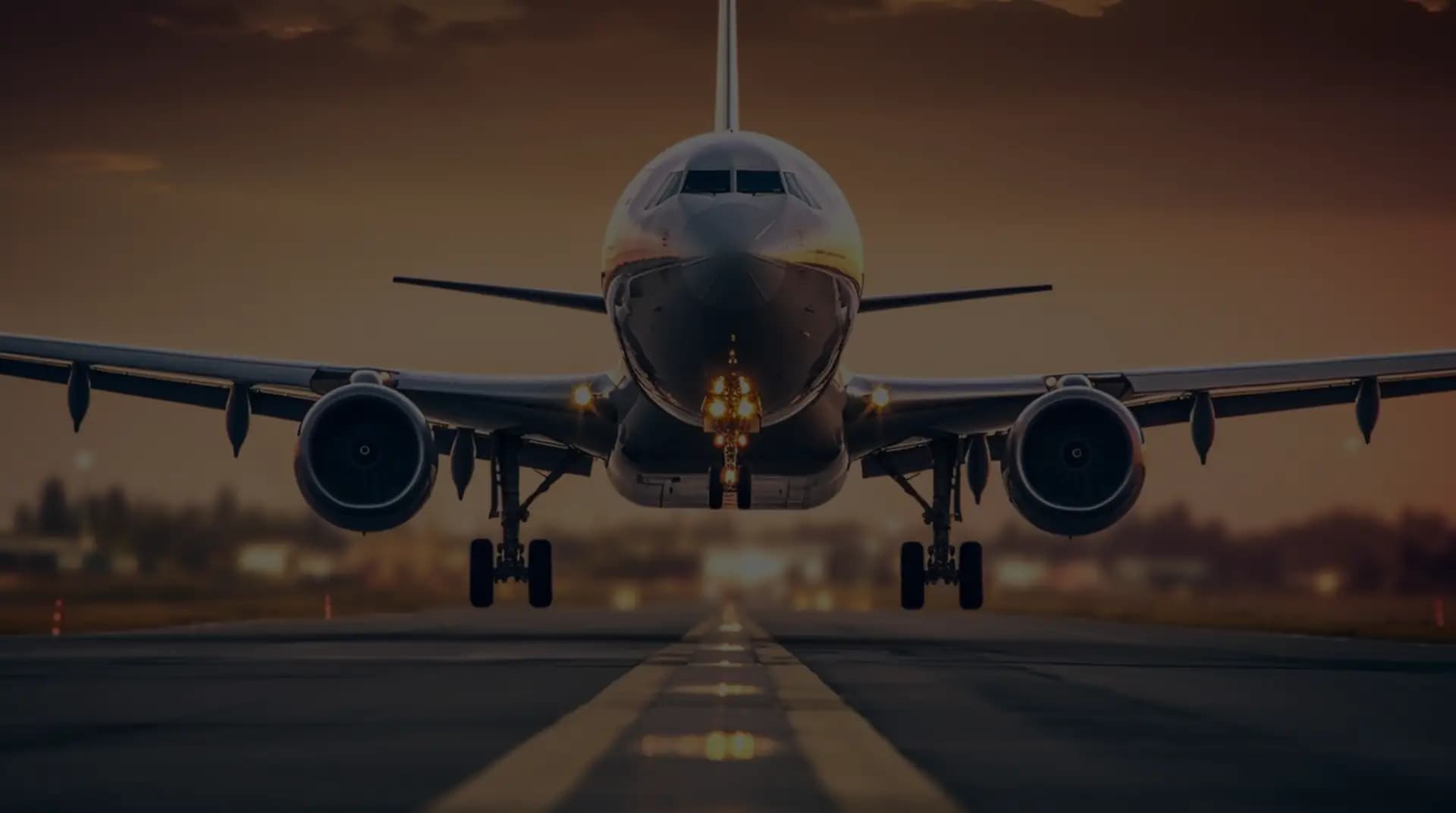 A commercial aircraft taking off head-on at sunset